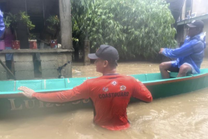 In this photo provided by Philippine Coast Guard, rescuers use a boat to evacuate residents at a flooded village as powerful Typhoon Krathon affects Laoag, Ilocos Norte, northern Philippines Monday, Sept. 30, 2024. (Philippine Coast Guard via AP)