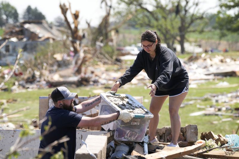 Local residents clean out their tornado damaged home, Wednesday, May 22, 2024, in Greenfield, Iowa. (AP Photo/Charlie Neibergall)