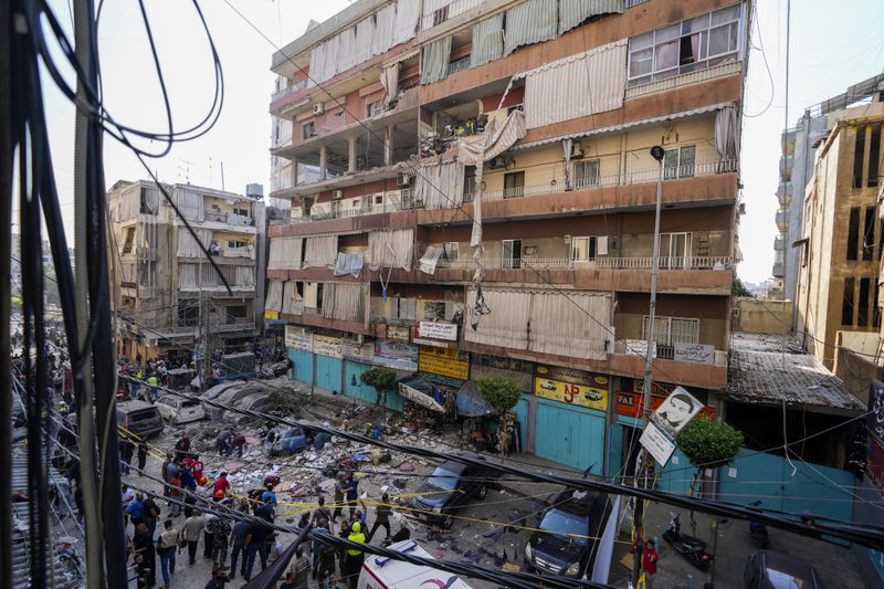 Residents and rescuers check a building that was hit by an Israeli airstrike in Beirut's southern suburbs, Tuesday, Sept. 24, 2024. (AP Photo/Hassan Ammar)