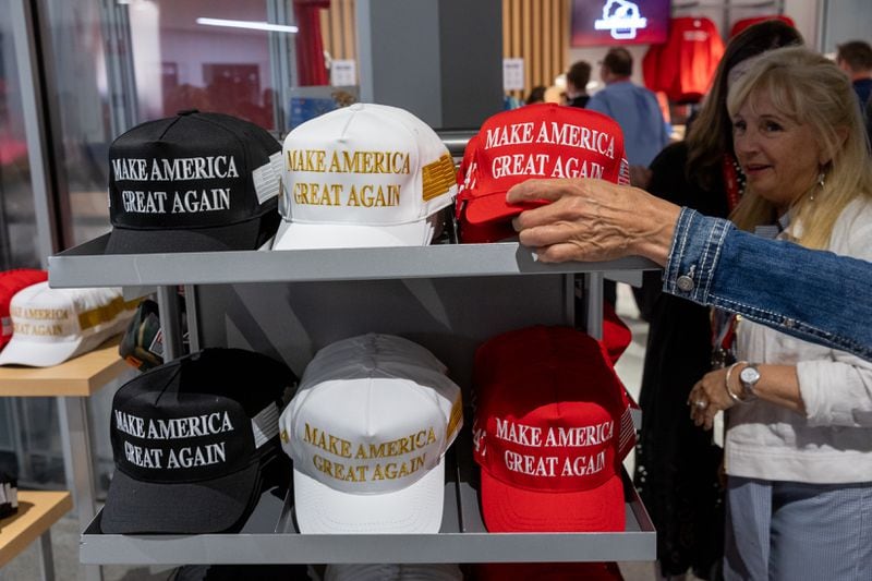 Supporters of former President Donald Trump browse a selection of his campaign hats.