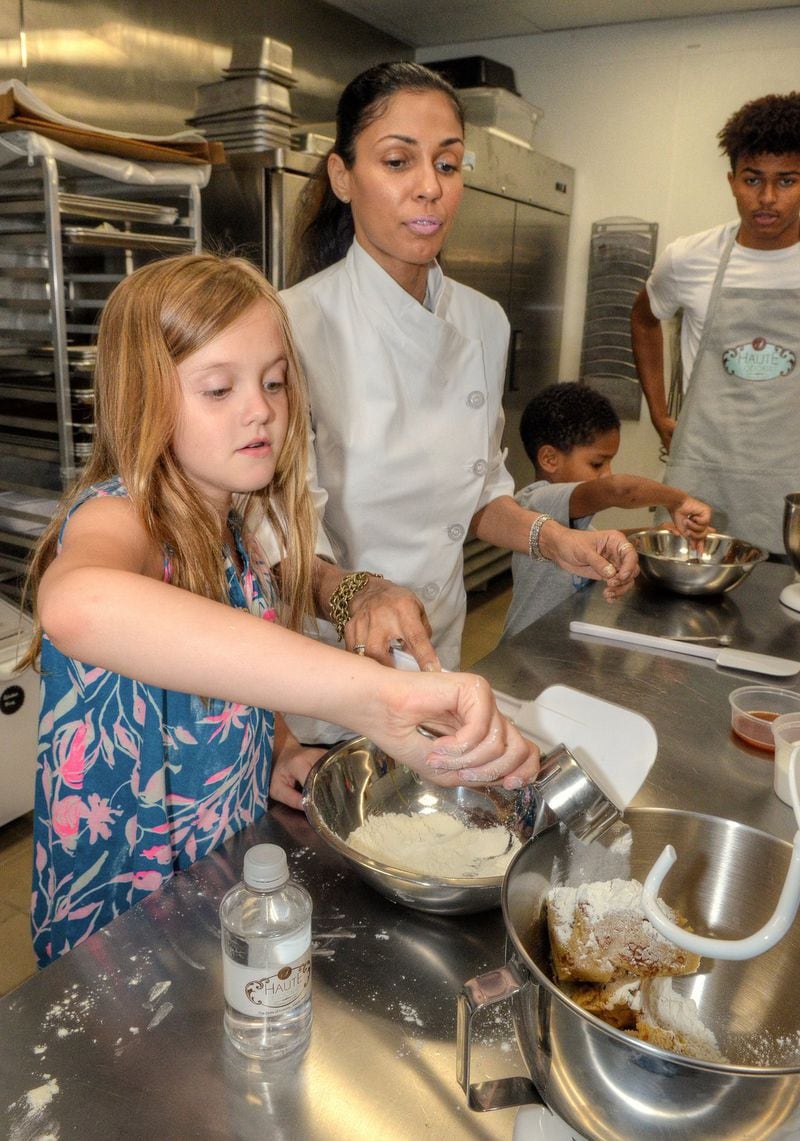 A Haute Cookie owner Shiana White instructs Harper Wright, 9, in making Edible Sugar Cookie Dough. In the background, Jacadi Robinson 8, is helped by White’s son Cory Curtis, 17, with his Edible Sugar Cookie Dough. CONTRIBUTED BY CHRIS HUNT PHOTOGRAPHY