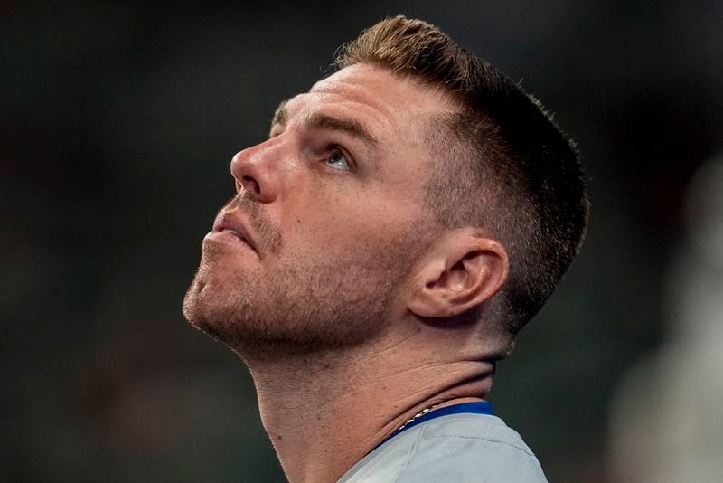 Los Angeles Dodgers first baseman Freddie Freeman (5) watches a fly ball from the dugoput in the fourth inning of a baseball game against the Atlanta Braves, Friday, Sept. 13, 2024, in Atlanta. (AP Photo/Mike Stewart)