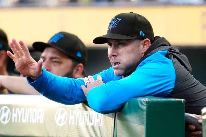 Miami Marlins manager Skip Schumaker, right, stands in the dugout during the first inning of a baseball game against the Pittsburgh Pirates in Pittsburgh, Monday, Sept. 9, 2024. (AP Photo/Gene J. Puskar)