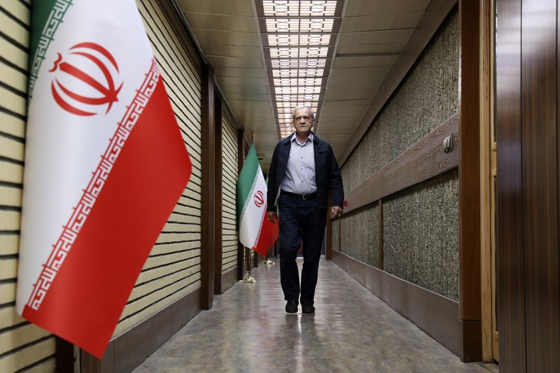 In this picture made available by Iranian state-run TV, IRIB, reformist presidential candidate for the June 28, election, Masoud Pezeshkian, arrives for a debate of the candidates at the TV studio in Tehran, Iran, Thursday, June 20, 2024. (Morteza Fakhri Nezhad/IRIB via AP)