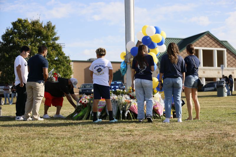 Mourners leave flowers and balloons outside Apalachee High School after Wednesday's shooting.