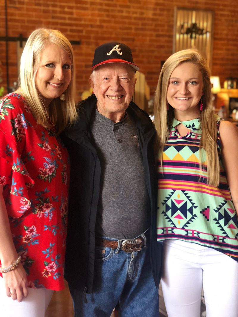 Hope Jones, left, who owns Plains Sweet Stems flower and gift shop, knew she'd have to be ready for the day when her hometown's most cherished resident, Jimmy Carter, died. The former president has helped support the store as a customer. He attended the shop's grand opening and posed for pictures, including this one with Jones and Jones' daughter, Bailey James. SPECIAL