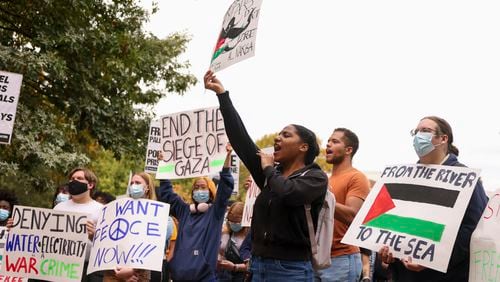 Student demonstrators hold a rally for Palestine in support of Palestinian, Arab, and Muslim students on the Tech Green on the Georgia Tech campus, Wednesday, October 25, 2023, in Atlanta. One demonstrator is holding a sign that reads "From the river to the sea." The slogan is seen by some Jewish organizations as antisemitic while Palestinian rights activists say it's a call for liberation. (Jason Getz / Jason.Getz@ajc.com)