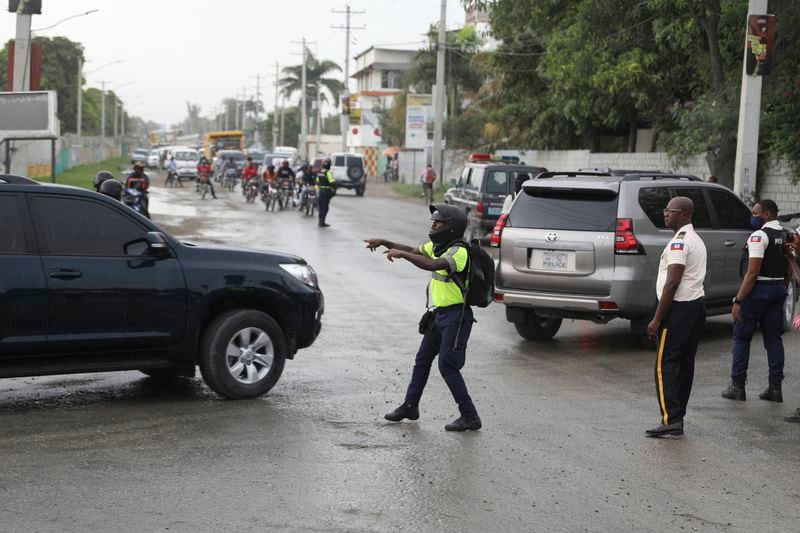 A police officer directs a caravan transporting Haiti's new Prime Minister Garry Conille, after he arrived at the airport in Port-au-Prince, Haiti, Saturday, June 1, 2024. (AP Photo/Odelyn Joseph)