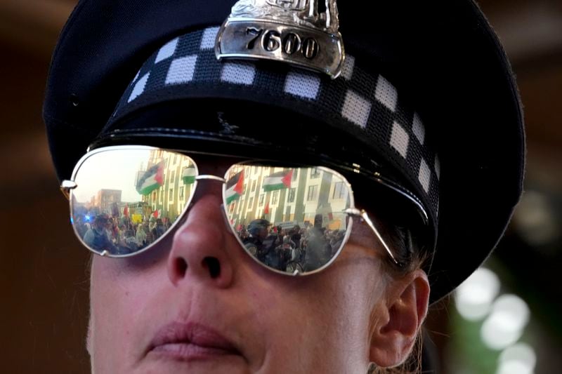 A police officer watches protesters march during a demonstration outside the Democratic National Convention Wednesday, Aug. 21, 2024, in Chicago. (AP Photo/Alex Brandon)