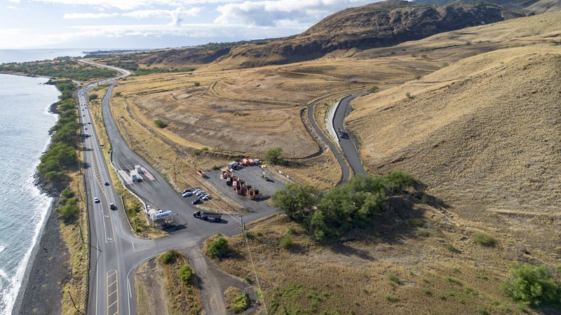 An aerial view shows a truck leaving the Olowalu temporary landfill site after dumping debris from the Lahaina fire on Sunday, July 7, 2024, in Lahaina, Hawaii. (AP Photo/Mengshin Lin)