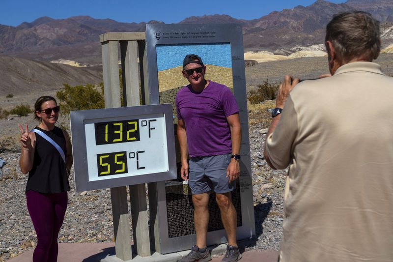 Melissa Bolding and Bryan Bolding from Oklahoma City pose for a photo next to a thermometer displaying a temperature of 132 degrees Fahrenheit / 55 degrees Celsius at the Furnace Creek Visitors Center, in Death Valley National Park, Calif., Sunday, July 07, 2024. Forecasters said a heat wave could break previous records across the U.S. including at Death Valley. (AP Photo/Ty ONeil)