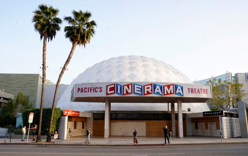 FILE - People appear outside the Cinerama Dome movie theater, Monday, April 12, 2021, in Los Angeles. (AP Photo/Chris Pizzello, File)