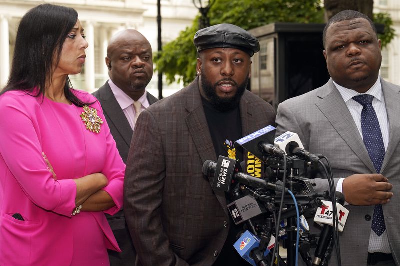 Shamel Kelly, center, flanked by his attorneys Bernarda Villalona, left, and Harry Daniels, right, speaks during a news conference in New York's City Hall Park, Tuesday, Oct. 1, 2024. (AP Photo/Richard Drew)