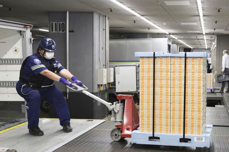 New banknotes are pulled to a vehicle to transport them to financial institutions, at the Bank of Japan headquarters in Tokyo, Japan, Wednesday, July 3, 2024. (Japan Pool/Kyodo News via AP)