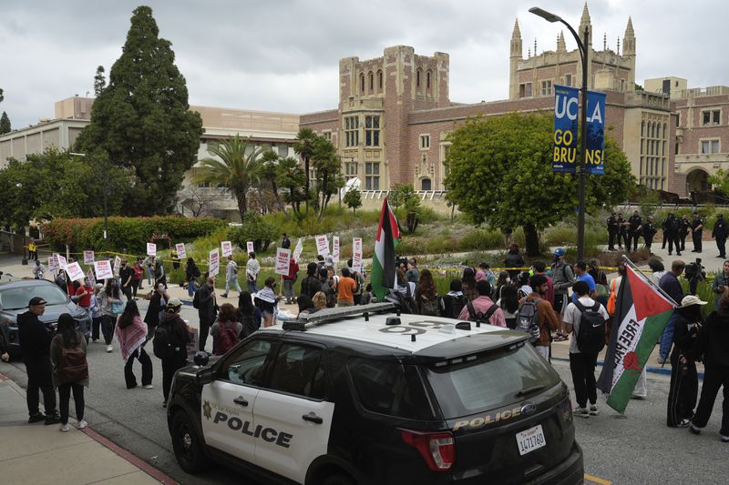Pro-Palestinian protesters carry signs and march along the campus of the University of California, Los Angeles on Thursday, May 23, 2024. (AP Photo/Damian Dovarganes)