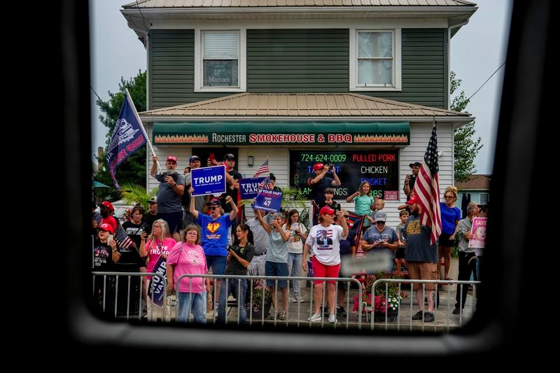 Supporters of Republican presidential nominee former President Donald Trump watch a campaign bus carrying Democratic presidential nominee Vice President Kamala Harris and her running mate Minnesota Gov. Tim Walz drive by, Sunday, Aug. 18, 2024, in Rochester, Pa. (AP Photo/Julia Nikhinson)