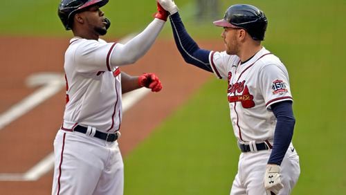 Atlanta Braves' Jorge Soler and Freddie Freeman celebrate after Soler's home run in the first inning of a baseball game against the Washington Nationals, Saturday, Aug. 7, 2021, in Atlanta. (AP Photo/Edward Pio Roda)