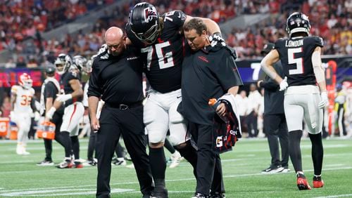 Atlanta Falcons offensive tackle Kaleb McGary (76) is carried by Falcons medical staff after an injury during the first half on Sunday, Sept. 22, 2024, at Mercedes-Benz Stadium in Atlanta.  (Miguel Martinez/ AJC)