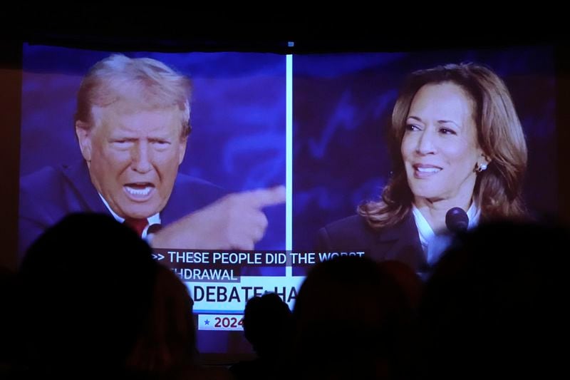 Republican presidential nominee former President Donald Trump, left, and Democratic presidential nominee Vice President Kamala Harris are seen on a screen during a presidential debate as people watch at One Longfellow Square, Tuesday, Sept. 10, 2024, in Portland, Maine. (AP Photo/Robert F. Bukaty)