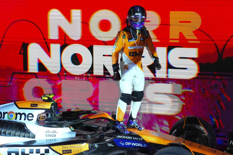 McLaren driver Lando Norris of Britain stands on his car as he celebrates after winning the Singapore Formula One Grand Prix at the Marina Bay Street Circuit, in Singapore, Sunday, Sept. 22, 2024. (AP Photo/Vincent Thian)