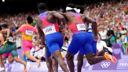 Christian Coleman, left, of the United States, struggles to hand the baton to teammate Kenneth Bednarek, in the men's 4x100-meter relay final at the 2024 Summer Olympics, Friday, Aug. 9, 2024, in Saint-Denis, France. (AP Photo/Bernat Armangue)