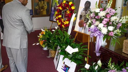 Lyndel Mason looks over the flowers and photographs before the start of funeral services Saturday for Imani Bell at the Hillside Chapel & Truth Center in Atlanta STEVE SCHAEFER / SPECIAL TO THE AJC