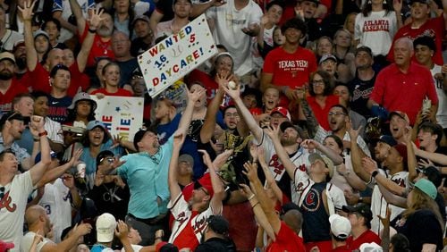 Baseball fans try to catch an home run ball by Philadelphia Phillies shortstop Trea Turner (7) during the sixth inning at Truist Park on Friday, July 5, 2024 in Atlanta. Philadelphia Phillies won 8-6 over Atlanta Braves. (Hyosub Shin / AJC)
