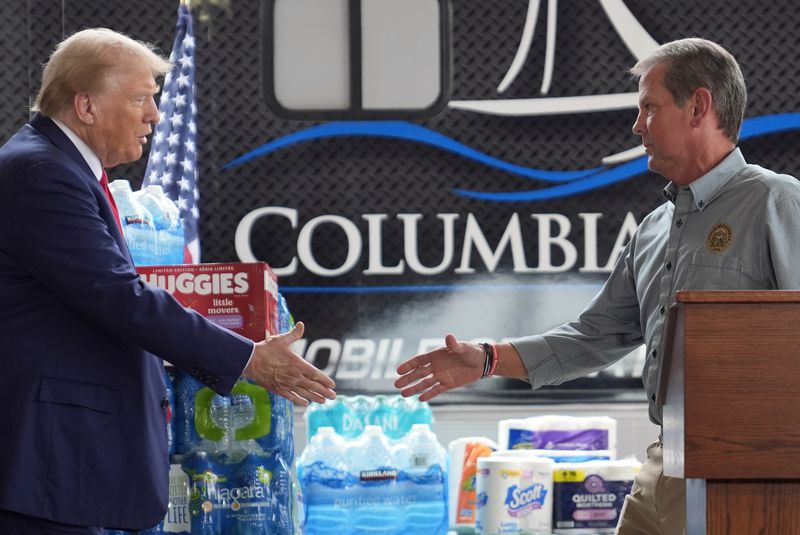 Republican presidential nominee former President Donald Trump shakes hands with Georgia Gov. Brian Kemp at a temporary relief shelter as he visits areas impacted by Hurricane Helene, Friday, Oct. 4, 2024, in Evans, Ga. (AP Photo/Evan Vucci)