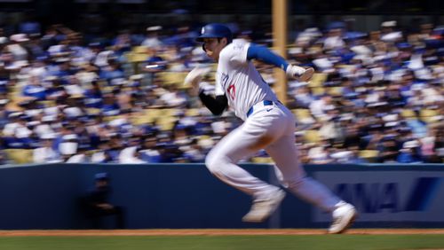 Los Angeles Dodgers' Shohei Ohtani heads to third as Freddie Freeman grounds into a double play to end the third inning of a baseball game against the Colorado Rockies, Sunday, Sept. 22, 2024, in Los Angeles. (AP Photo/Mark J. Terrill)