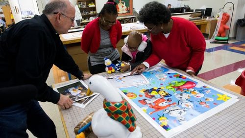 John Piper, vice president of Macy’s Parade Studio, shares the sketch of the Aflac Duck balloonicle with 10-year-old Teryn Buster, her mother, Tiffany Harris and grandmother, Linda Lias. BENNETT RAGLIN