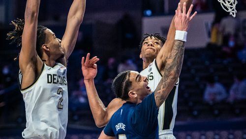 Georgia Tech guard Michael Devoe (0) shoots under defense from Wake Forest forward Ody Oguama, right, during an NCAA college basketball game Friday, March 5, 2021, in Winston-Salem, N.C. (Andrew Dye/The Winston-Salem Journal via AP)