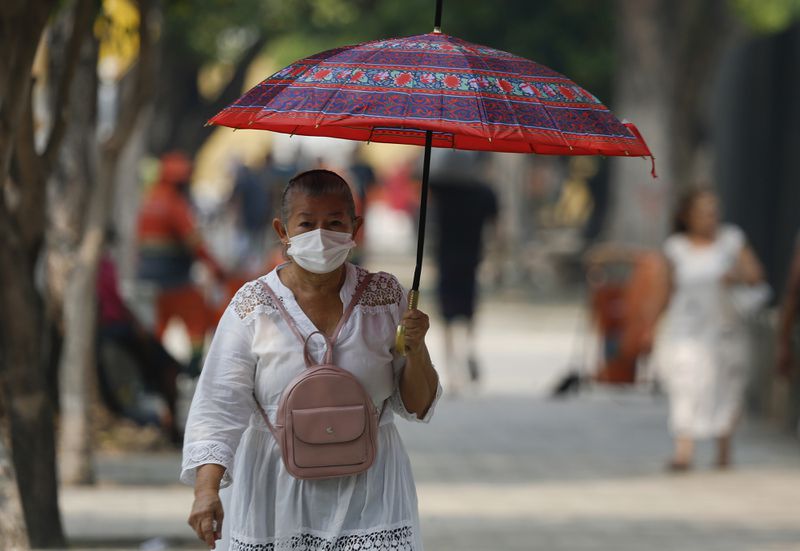 A pedestrian wears a mask due to smoke from wildfires reaching Manaus, Amazonas state, Brazil, Tuesday, Aug. 27, 2024. (AP Photo/Edmar Barros)