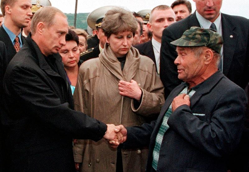 FILE - Russian President Vladimir Putin greets an unidentified relative of a seaman who was believed killed aboard the nuclear submarine Kursk at the military base of Vedyayevo, 50 miles (80 kilometers) north of Murmansk, Russia, on Aug. 22, 2000. (AP Photo/POOL, File)