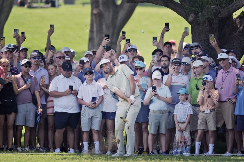 Scottie Scheffler hits from the gallery on the second hole during the final round of the Charles Schwab Challenge golf tournament at Colonial Country Club in Fort Worth, Texas, Sunday, May 26, 2024. (AP Photo/LM Otero
