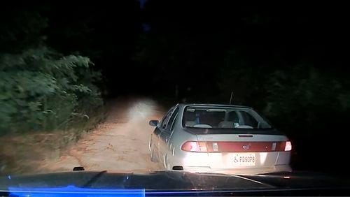 This image from a dashboard-mounted video camera on a Georgia State Patrol cruiser shows the car Julian Lewis was driving on Aug. 7, 2020, in Screven County, Georgia, while being pursued by a state trooper who knocked Lewis' car into a ditch and then fatally shot him. Trooper 1st Class Jacob Thompson said he tried to pull over Lewis' car because of a broken taillight. Thompson was fired and charged with murder, but walked free after a grand jury declined to indict him. The newly released dash camera video raises new questions about the shooting. (Georgia Department of Public Safety/Ebony Reed, Louise Story via AP)