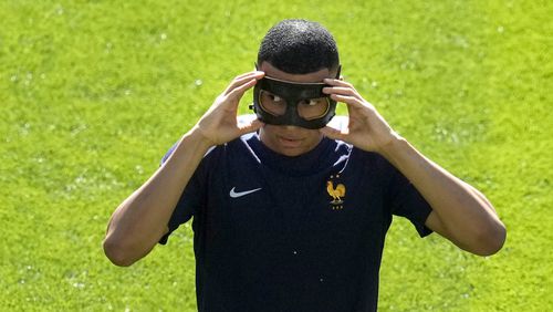 Kylian Mbappe of France fits a protective goggles ahead of a Group D match between the France and Poland at the Euro 2024 soccer tournament in Dortmund, Germany, Tuesday, June 25, 2024. (AP Photo/Themba Hadebe)