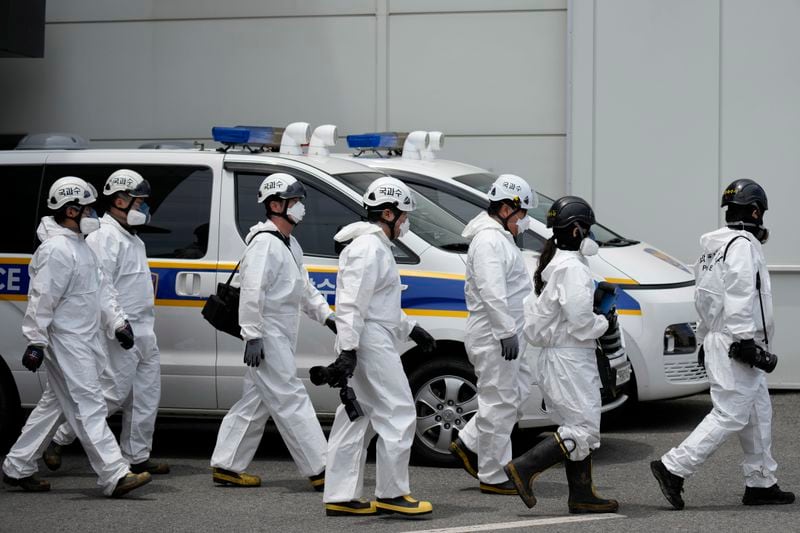 Members of the National Forensic Service walk to the site of a burnt battery manufacturing factory in Hwaseong, South Korea, Tuesday, June 25, 2024. (AP Photo/Lee Jin-man)