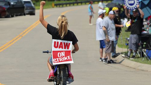 Lear production worker Abigail Fletcher rides her mini bike in support of the picket line as members of United Auto Workers Local 282 continue their strike against the car and truck seat manufacturer in Wentzville, Mo. on Tuesday, July 23, 2024. The strike led to a shutdown at the nearby GM assembly plant. (Robert Cohen/St. Louis Post-Dispatch via AP)