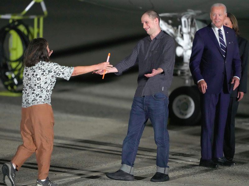 Journalist Evan Gershkovich is greeted by his mother, Ella Milman, as President Joe Biden and Kamala Harris look on at Andrews Air Force Base in Maryland on Thursday.