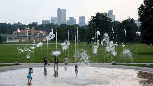 Haze hangs in the air as children play in a fountain in Denver , Wednesday, July 24, 2024. Fires burning in California, Oregon, Arizona, Washington and other western states, as well as Canada, have filled the skies in regions of the western U.S. with smoke and haze, forcing some affected areas to declare air quality alerts or advisories. (AP Photo/Thomas Peipert)