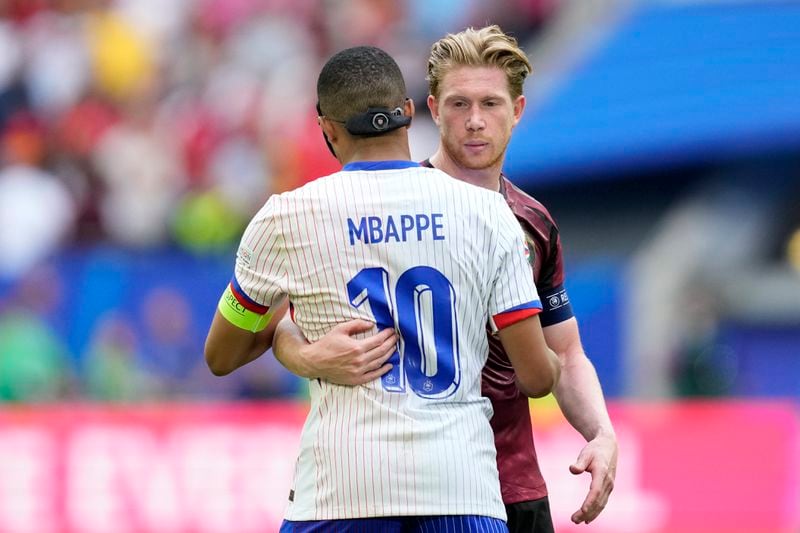 Belgium's Kevin De Bruyne and Kylian Mbappe of France embrace at the end of a round of sixteen match between France and Belgium at the Euro 2024 soccer tournament in Duesseldorf, Germany, Monday, July 1, 2024. France won 1-0. (AP Photo/Darko Vojinovic)