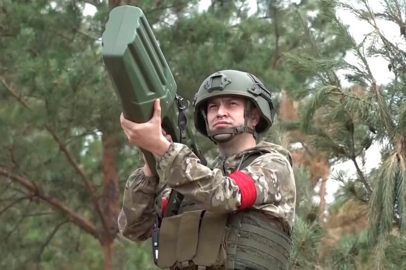 In this photo released by Russian Defense Ministry press service on Thursday, Aug. 22, 2024, a Russian serviceman aims a PARS-NU anti-drone gun in an undisclosed location. (Russian Defense Ministry Press Service via AP)