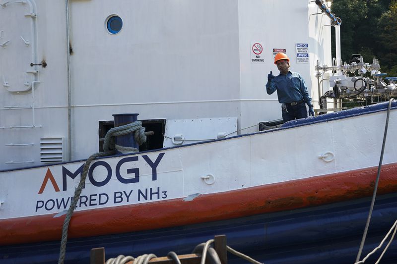 Worker gestures from the NH3 Kraken, a tugboat powered by ammonia, Friday, Sept. 13, 2024, in Kingston, N.Y. (AP Photo/Alyssa Goodman)