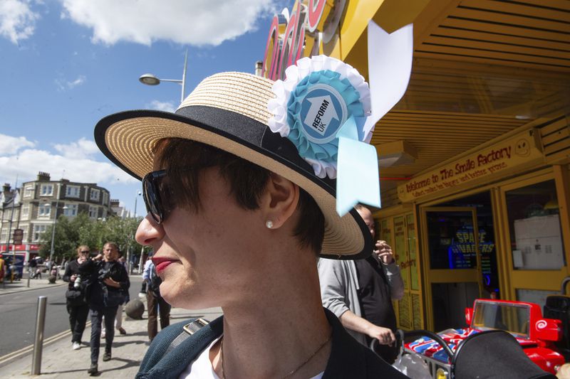 A woman displays a Reform UK Party badge on her hat in Clacton On Sea, England, Thursday, July 4, 2024. Voters in the U.K. are casting their ballots in a national election to choose the 650 lawmakers who will sit in Parliament for the next five years. Outgoing Prime Minister Rishi Sunak surprised his own party on May 22 when he called the election. (AP Photo/Thomas Krych)