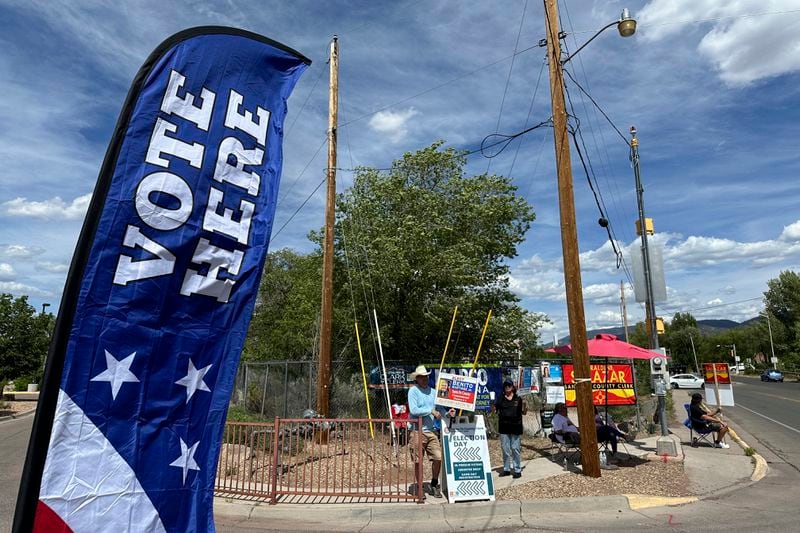 Political campaign supporters greet voters as they turn into a polling location in Santa Fe, N.M., Tuesday, June 4, 2024. New Mexico voters were picking their partisan favorites in the state's primary election to reshape a Democratic-led Legislature, with all 112 seats up for election in November. (AP Photo/Morgan Lee)