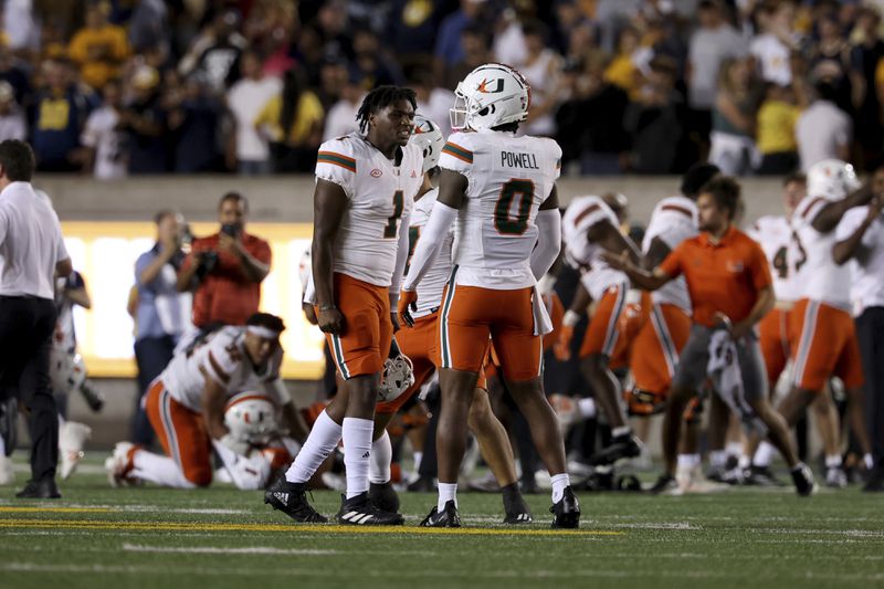 Miami quarterback Cam Ward (1) and and defensive back Mishael Powell (0) celebrate against California during the second half of an NCAA college football game in Berkeley, Calif., Saturday, Oct. 5, 2024. (AP Photo/Jed Jacobsohn)