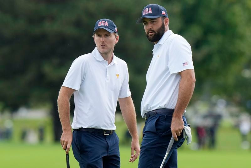 United States team members Scottie Scheffler, right, and Russell Henley line up a putt on the second hole during a first round four-ball match at the Presidents Cup golf tournament at the Royal Montreal Golf Club in Montreal, Thursday, Sept. 26, 2024. (Frank Gunn/The Canadian Press via AP)