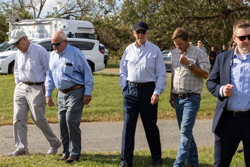 President Joe Biden walks with farmer Buck Paulk at his pecan farm in Ray City on Thursday. Paulk described the recovery from the storm as a "mighty struggle." "It’s disheartening. It’s expensive. ... We’re just not going to snap back from this,” he said. (Arvin Temkar / AJC)
