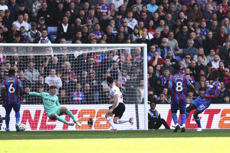 Liverpool's Diogo Jota, centre, scores the opening goal past Crystal Palace's goalkeeper Dean Henderson during the English Premier League soccer match between Crystal Palace and Liverpool at Selhurst Park in London, Saturday, Oct. 5, 2024.(AP Photo/Ian Walton)