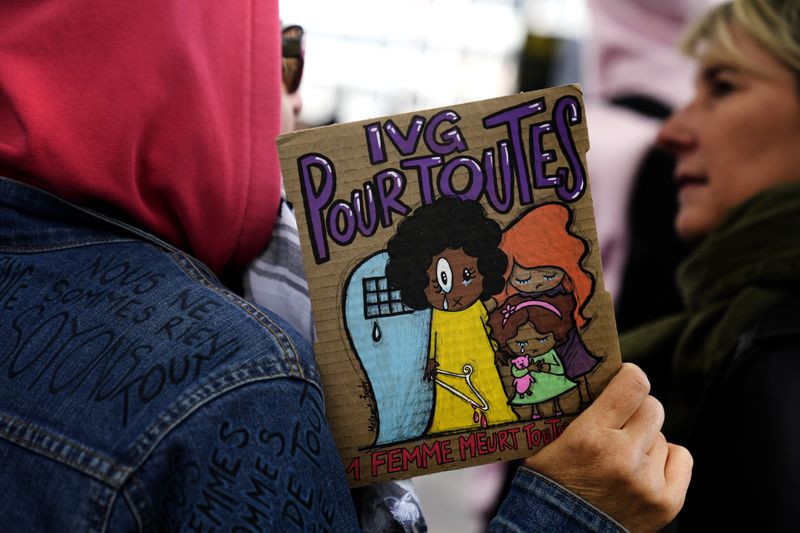 A demonstrator holds a board reading: Abortion for all, during a march in support of the right to abortion for women across the world, in Paris, Saturday, Sept. 28, 2024. (AP Photo/Christophe Ena)